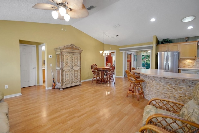 2766 Privada Dr, The Villages, FL 32162 - kitchen featuring freestanding refrigerator, ceiling fan, light wood-style floors, vaulted ceiling, and a chandelier