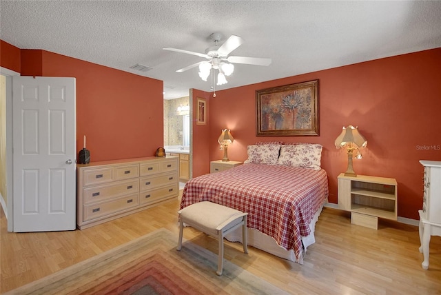 2766 Privada Dr, The Villages, FL 32162 - bedroom featuring light wood-style floors, a textured ceiling, baseboards, and ceiling fan