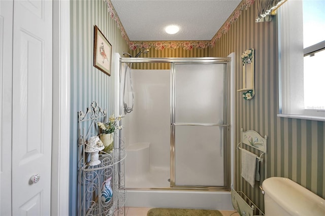 2766 Privada Dr, The Villages, FL 32162 - bathroom featuring wallpapered walls, a textured ceiling, a stall shower, and toilet