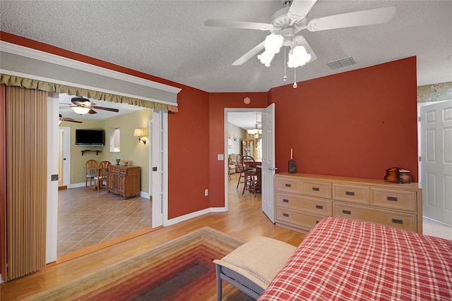 2766 Privada Dr, The Villages, FL 32162 - bedroom featuring light wood-type flooring, a textured ceiling, and baseboards