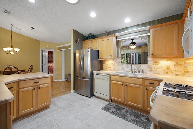 2766 Privada Dr, The Villages, FL 32162 - kitchen featuring white appliances, a sink, backsplash, vaulted ceiling, and light countertops