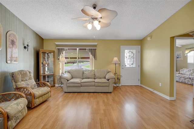 2766 Privada Dr, The Villages, FL 32162 - living area with ceiling fan, light wood finished floors, a textured ceiling, and baseboards