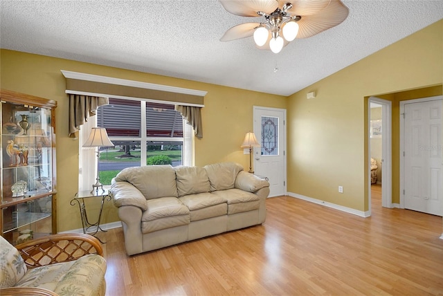 2766 Privada Dr, The Villages, FL 32162 - living area with wood finished floors, ceiling fan, a textured ceiling, baseboards, and vaulted ceiling