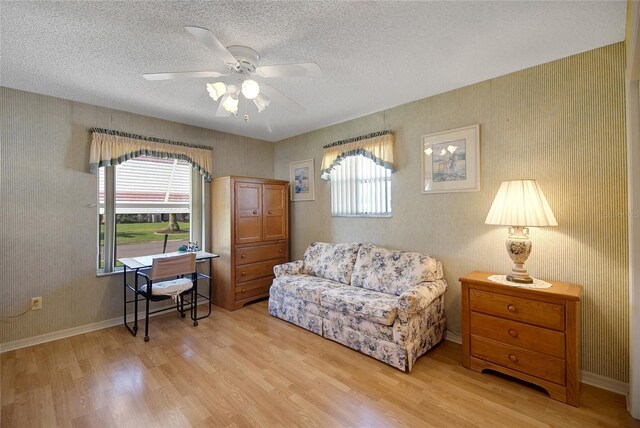 2766 Privada Dr, The Villages, FL 32162 - living area featuring light wood finished floors, ceiling fan, baseboards, a textured ceiling, and wallpapered walls
