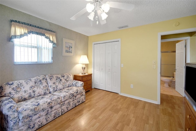 2766 Privada Dr, The Villages, FL 32162 - living area featuring light wood-style floors, a ceiling fan, a textured ceiling, and baseboards
