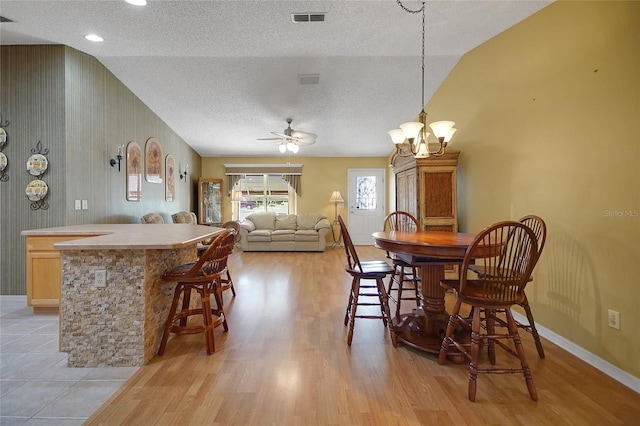 2766 Privada Dr, The Villages, FL 32162 - dining space featuring a textured ceiling, vaulted ceiling, light wood-type flooring, baseboards, and a ceiling fan