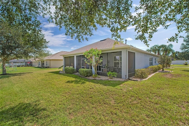 11601 Thacker Dr, Clermont, FL 34711 - back of property with a sunroom, a lawn, and stucco siding
