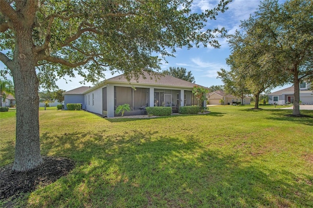 11601 Thacker Dr, Clermont, FL 34711 - rear view of house with a yard, a sunroom, and stucco siding