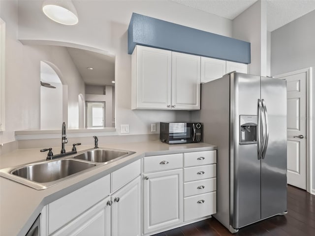 628 San Pedro Dr, The Villages, FL 32159 - kitchen with stainless steel fridge, black microwave, white cabinets, and light countertops