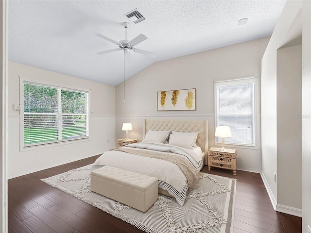 628 San Pedro Dr, The Villages, FL 32159 - bedroom featuring vaulted ceiling, dark wood-style floors, a textured ceiling, and a ceiling fan