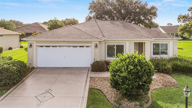 13643 SE 89th Ct, Summerfield, FL 34491 - ranch-style home featuring concrete driveway, an attached garage, stucco siding, a front yard, and roof with shingles