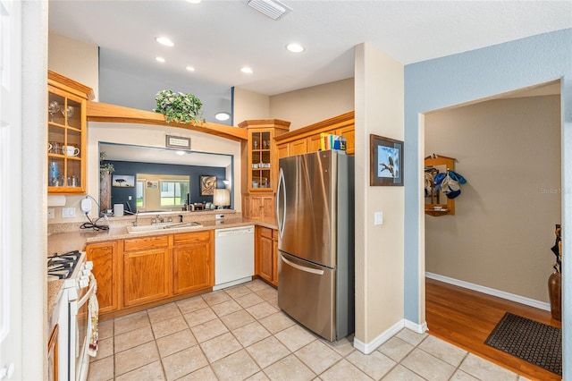13643 SE 89th Ct, Summerfield, FL 34491 - kitchen with white appliances, recessed lighting, light countertops, light tile patterned floors, and glass insert cabinets