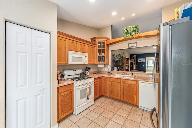13643 SE 89th Ct, Summerfield, FL 34491 - kitchen featuring white appliances, light countertops, light tile patterned floors, glass insert cabinets, and a sink