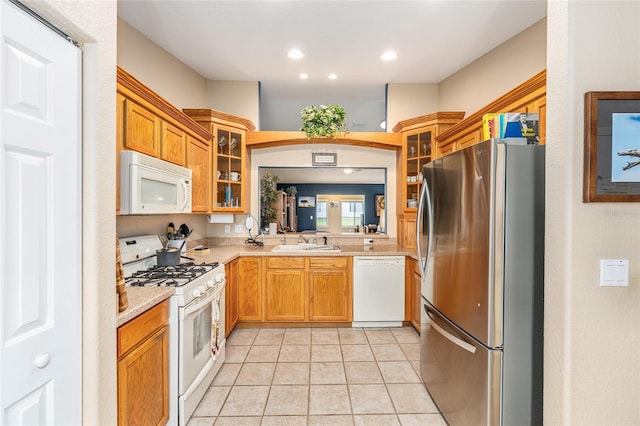 13643 SE 89th Ct, Summerfield, FL 34491 - kitchen featuring white appliances, a sink, glass insert cabinets, recessed lighting, and light tile patterned floors