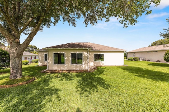 13643 SE 89th Ct, Summerfield, FL 34491 - rear view of house with a lawn, stucco siding, and cooling unit