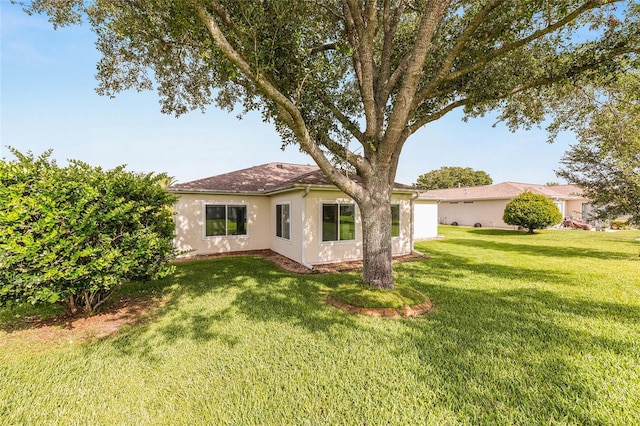 13643 SE 89th Ct, Summerfield, FL 34491 - back of house featuring stucco siding and a yard