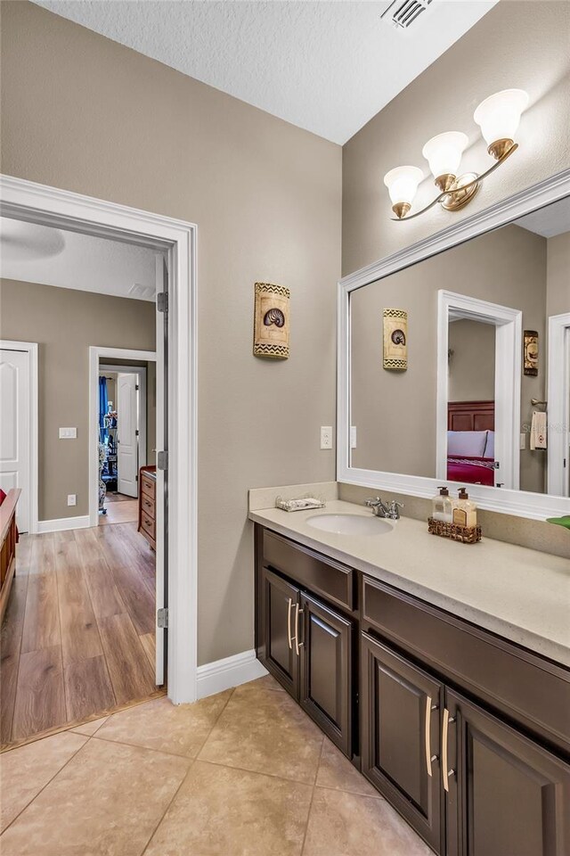 3222 San Leo Dr, Orlando, FL 32820 - bathroom with vanity, tile patterned floors, baseboards, and ensuite bathroom