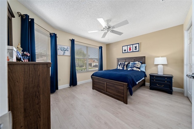 9430 SE 176th Saffold St, The Villages, FL 32162 - bedroom with a textured ceiling, light wood finished floors, baseboards, and ceiling fan
