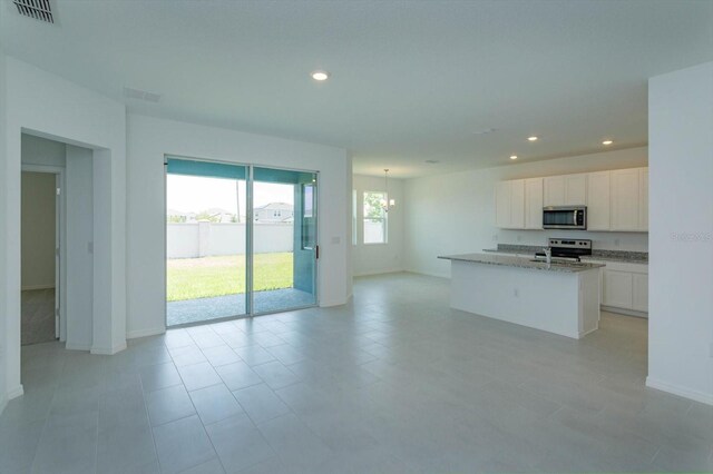 520 Silver Palm Dr, Haines City, FL 33844 - kitchen featuring appliances with stainless steel finishes, recessed lighting, white cabinets, baseboards, and a kitchen island with sink