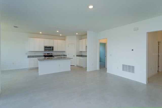 520 Silver Palm Dr, Haines City, FL 33844 - kitchen with stainless steel appliances, open floor plan, white cabinets, an island with sink, and recessed lighting