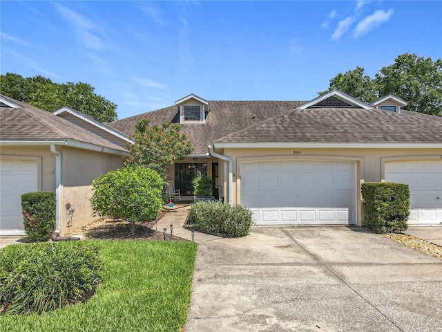 264 Juniper Way, Tavares, FL 32778 - view of front of home featuring concrete driveway, stucco siding, roof with shingles, and an attached garage