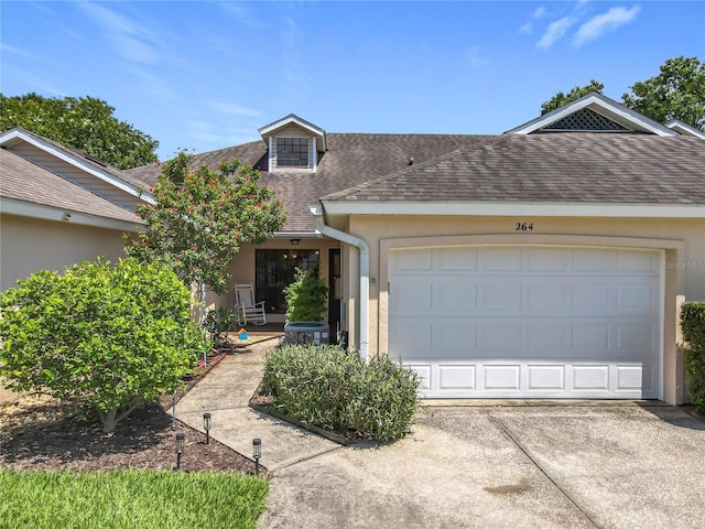 264 Juniper Way, Tavares, FL 32778 - view of front facade with a shingled roof, concrete driveway, stucco siding, a garage, and central AC