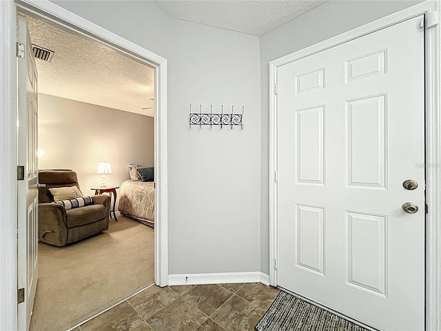 264 Juniper Way, Tavares, FL 32778 - entryway featuring a textured ceiling, baseboards, and dark colored carpet