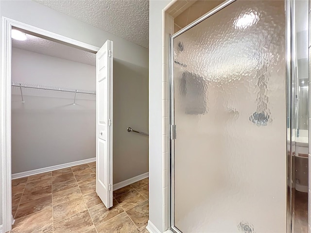 264 Juniper Way, Tavares, FL 32778 - full bath featuring a stall shower, a walk in closet, a textured ceiling, and baseboards
