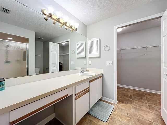 264 Juniper Way, Tavares, FL 32778 - full bath with a shower stall, vanity, a spacious closet, a textured ceiling, and baseboards