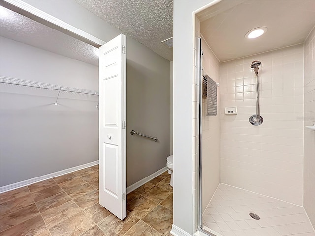 264 Juniper Way, Tavares, FL 32778 - bathroom featuring a shower stall, toilet, a walk in closet, baseboards, and a textured ceiling