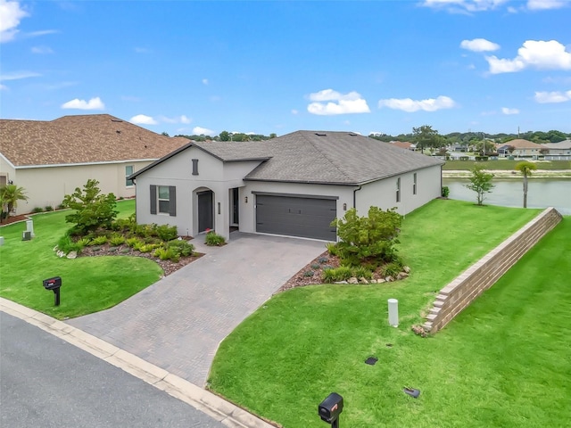 17108 SE 111th Terrace Rd, Summerfield, FL 34491 - view of front of house with stucco siding, decorative driveway, an attached garage, and a water view