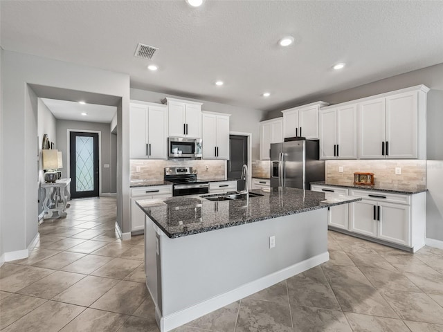 17108 SE 111th Terrace Rd, Summerfield, FL 34491 - kitchen with appliances with stainless steel finishes, a sink, backsplash, a center island with sink, and white cabinets