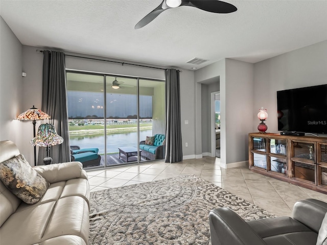 17108 SE 111th Terrace Rd, Summerfield, FL 34491 - living room with ceiling fan, tile patterned floors, a textured ceiling, and baseboards
