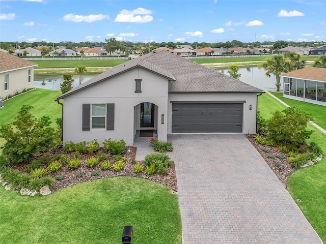 17108 SE 111th Terrace Rd, Summerfield, FL 34491 - view of front of home with a garage, a residential view, a water view, stucco siding, and decorative driveway