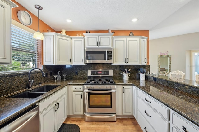 8039 SE 174th Belhaven Loop, The Villages, FL 32162 - kitchen with appliances with stainless steel finishes, a sink, backsplash, pendant lighting, and light wood-style flooring