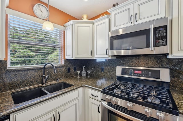8039 SE 174th Belhaven Loop, The Villages, FL 32162 - kitchen featuring appliances with stainless steel finishes, a sink, white cabinets, backsplash, and hanging light fixtures