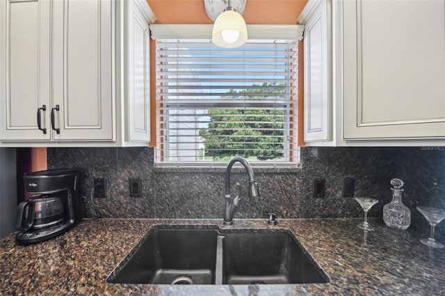8039 SE 174th Belhaven Loop, The Villages, FL 32162 - kitchen with a sink, white cabinets, backsplash, and dark stone countertops
