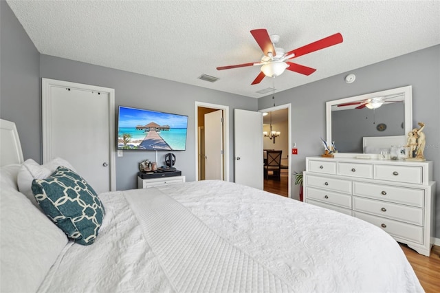 8039 SE 174th Belhaven Loop, The Villages, FL 32162 - bedroom featuring wood finished floors, a textured ceiling, and ceiling fan