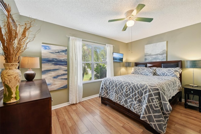 8039 SE 174th Belhaven Loop, The Villages, FL 32162 - bedroom with a textured ceiling, baseboards, hardwood / wood-style flooring, and ceiling fan