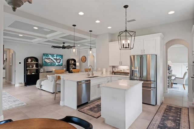 9512 Mid Summer Ln, Leesburg, FL 34788 - kitchen with arched walkways, appliances with stainless steel finishes, open floor plan, a sink, and coffered ceiling