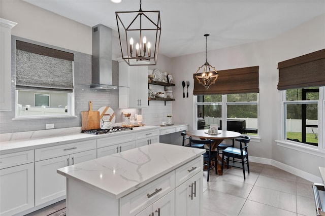 9512 Mid Summer Ln, Leesburg, FL 34788 - kitchen featuring a chandelier, stainless steel gas cooktop, wall chimney exhaust hood, backsplash, and white cabinetry