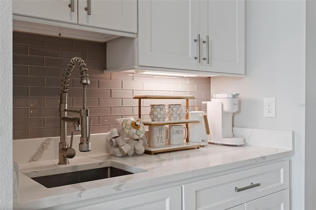 9512 Mid Summer Ln, Leesburg, FL 34788 - kitchen with a sink, decorative backsplash, white cabinets, and light stone counters