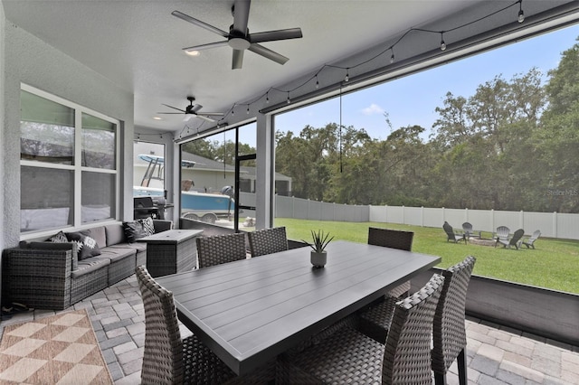 9512 Mid Summer Ln, Leesburg, FL 34788 - sunroom / solarium featuring a ceiling fan, outdoor dining area, and an outdoor living space with a fire pit