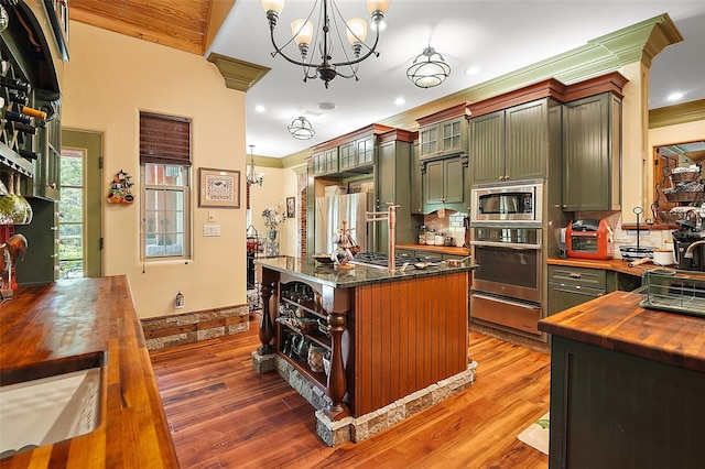 707 S Dixie Dr, Howey In The Hills, FL 34737 - kitchen featuring stainless steel appliances, wood counters, a warming drawer, a chandelier, and green cabinets