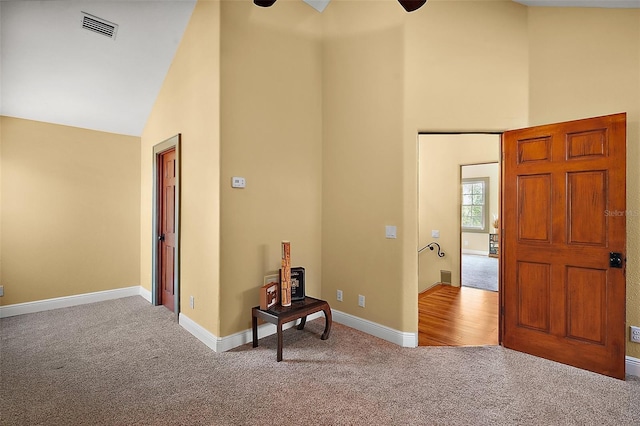 707 S Dixie Dr, Howey In The Hills, FL 34737 - foyer entrance featuring carpet, high vaulted ceiling, ceiling fan, and baseboards