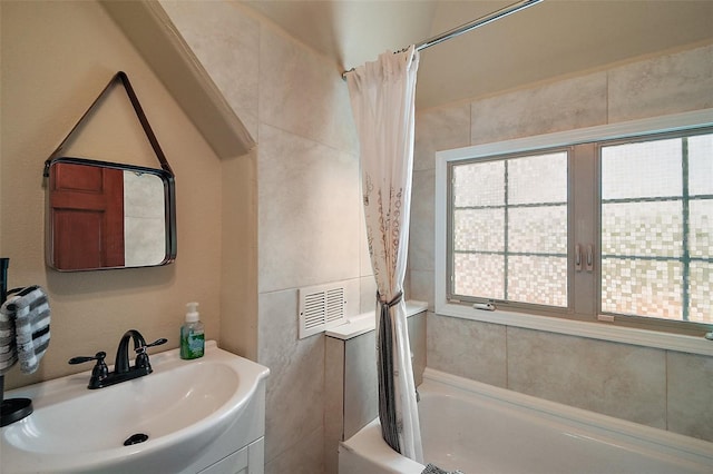 707 S Dixie Dr, Howey In The Hills, FL 34737 - bathroom featuring healthy amount of natural light, shower / tub combo with curtain, and vanity