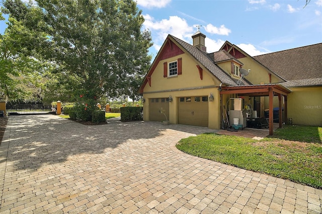 707 S Dixie Dr, Howey In The Hills, FL 34737 - view of front facade with stucco siding, a garage, decorative driveway, a chimney, and roof with shingles