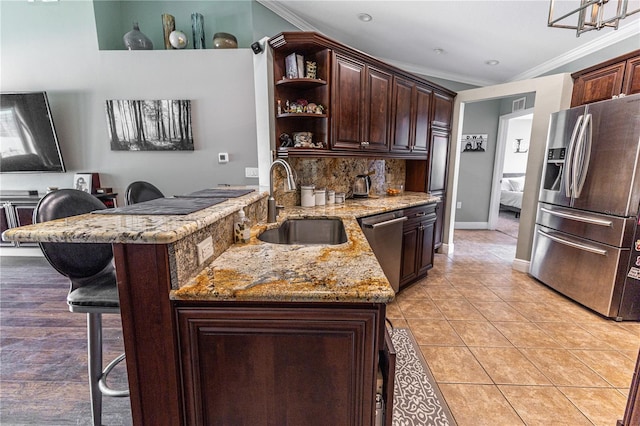 5437 Compass Pt Unit 00, Oxford, FL 34484 - kitchen with stainless steel appliances, a sink, crown molding, a breakfast bar, and open shelves