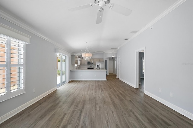 997 Oscar Ln, The Villages, FL 32162 - unfurnished living room with dark wood-type flooring, a chandelier, ceiling fan, crown molding, and baseboards