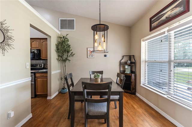 5521 Oak St, Mount Dora, FL 32757 - dining room with lofted ceiling, wood finished floors, and baseboards